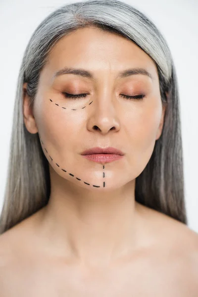 Attractive nude asian woman with closed eyes and plastic surgery correction mark on face isolated on grey — Stock Photo