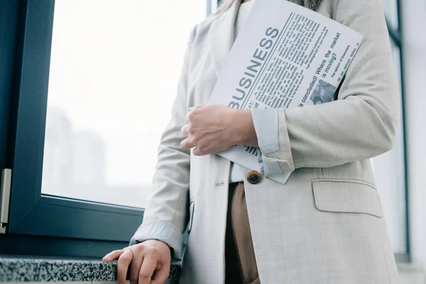 Ausgeschnittene Sicht auf professionelle Geschäftsfrau, die Wirtschaftszeitung im Amt hält — Stockfoto