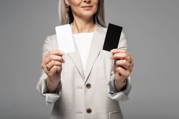 Cropped view of businesswoman holding business cards isolated on grey — Stock Photo