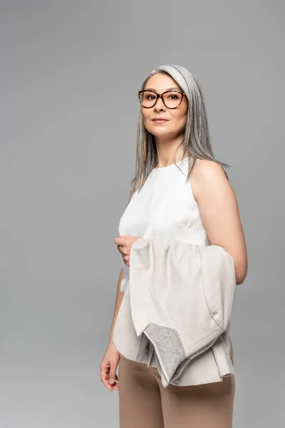 Fiduciosa donna d'affari asiatica in occhiali isolati su grigio — Foto stock