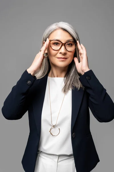 Asiatische Geschäftsfrau mit grauen Haaren in Brille isoliert auf grau — Stockfoto