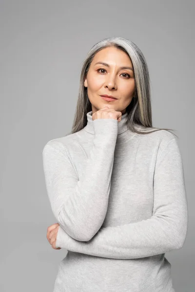 Thoughtful asian woman in turtleneck with grey hair and closed eyes isolated on grey — Stock Photo