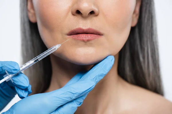 Cropped view of naked adult woman and doctor in latex gloves holding syringe with beauty injection isolated on grey — Stock Photo