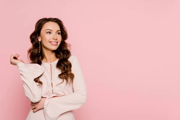 Pretty girl smiling and looking away isolated on pink — Stock Photo