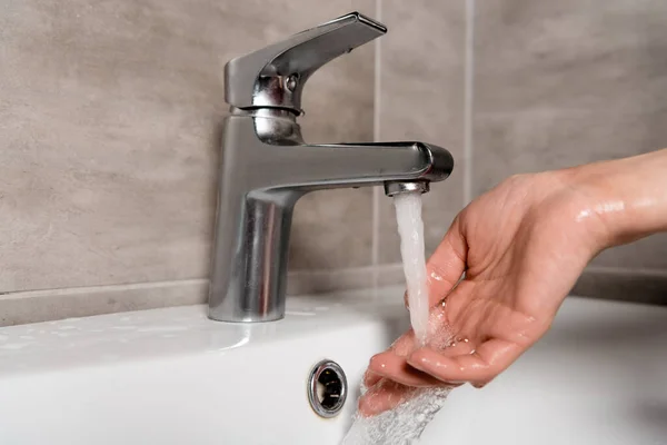 Vista recortada de la mujer lavándose la mano en el baño - foto de stock