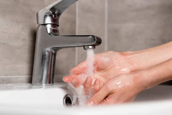 Enfoque selectivo de la mujer lavándose las manos en el baño - foto de stock