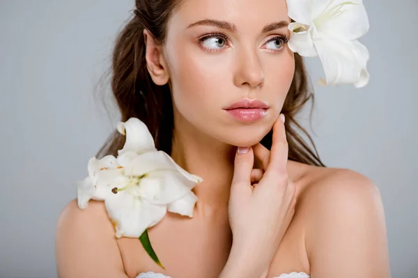 White flowers near beautiful woman touching face isolated on grey — Stock Photo