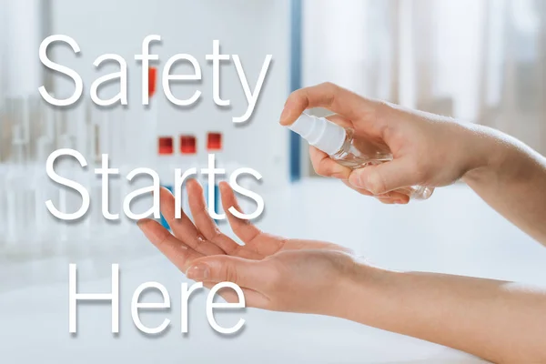 Cropped view of doctor spraying antiseptic on hands near test tubes, safety starts here illustration — Stock Photo