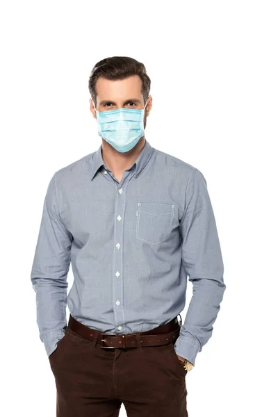 Geschäftsmann in blauer medizinischer Maske, die Hände in Taschen isoliert auf weißem Grund stehend — Stockfoto