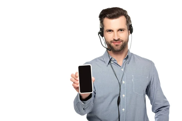Schöner Bediener im Headset hält Smartphone mit leerem Bildschirm isoliert auf weiß — Stockfoto