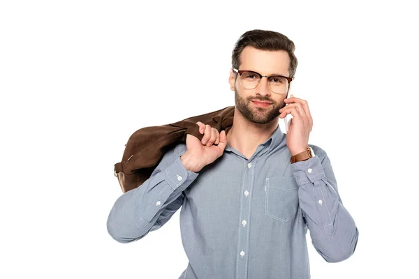 Glücklicher und bärtiger Geschäftsmann, der Tasche in der Hand hält und auf dem Smartphone isoliert auf weißem Grund spricht — Stockfoto