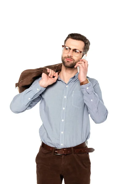 Guapo hombre de negocios sosteniendo bolsa y hablando en el teléfono inteligente aislado en blanco - foto de stock