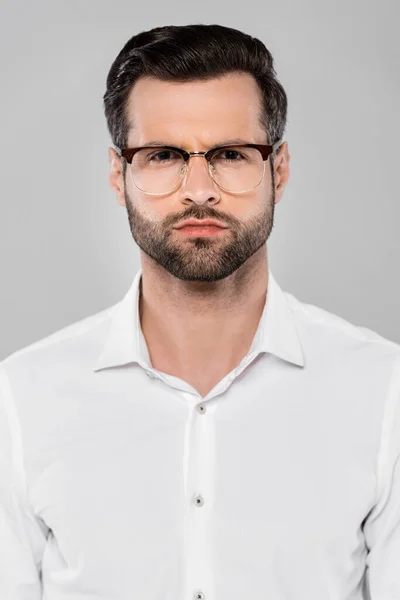 Бородатый мужчина в очках смотрит на камеру, изолированную на сером — стоковое фото