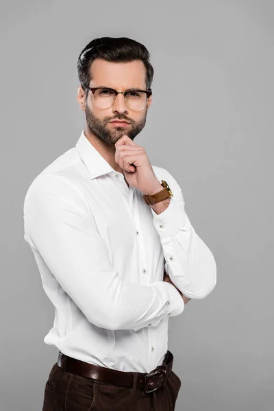 Bärtiger Geschäftsmann mit Brille berührt Gesicht isoliert auf grau — Stockfoto