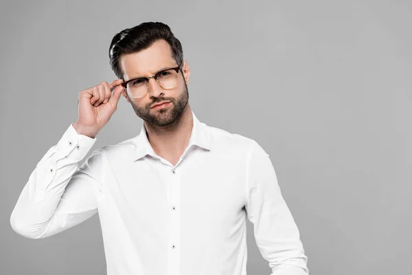 Beau homme d'affaires touchant lunettes isolées sur gris — Photo de stock