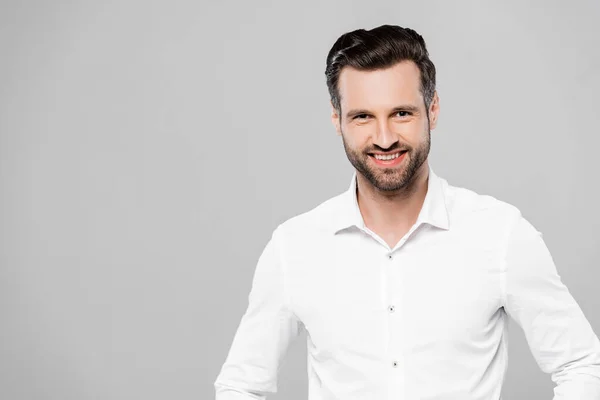 Sonriente hombre de negocios en camisa blanca mirando a la cámara aislada en gris — Stock Photo