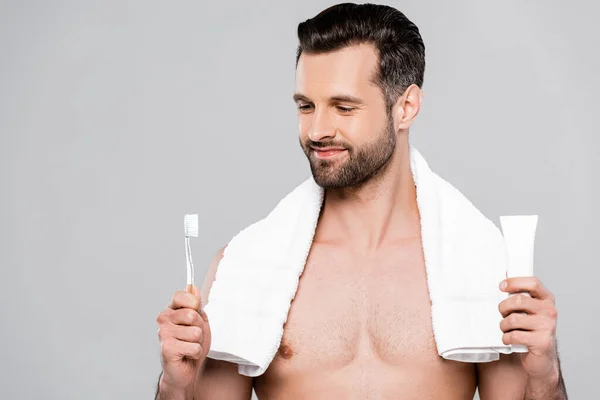 Happy bearded man looking at toothbrush isolated on grey — Stock Photo