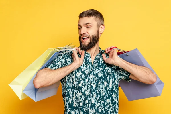 Emotionaler bärtiger Typ mit Einkaufstüten auf Gelb — Stockfoto