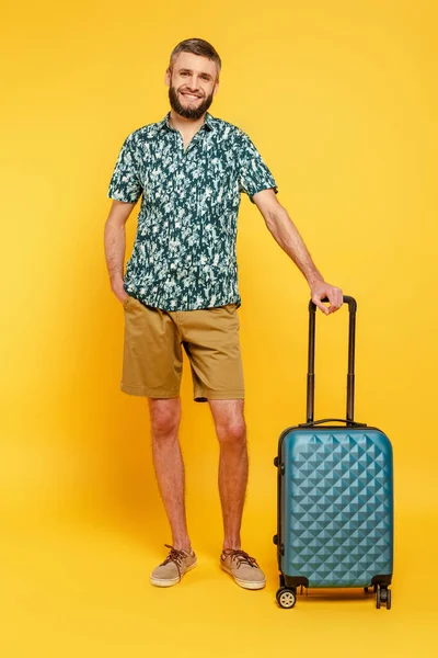 Visão de comprimento total do cara barbudo feliz com saco de viagem no amarelo — Fotografia de Stock