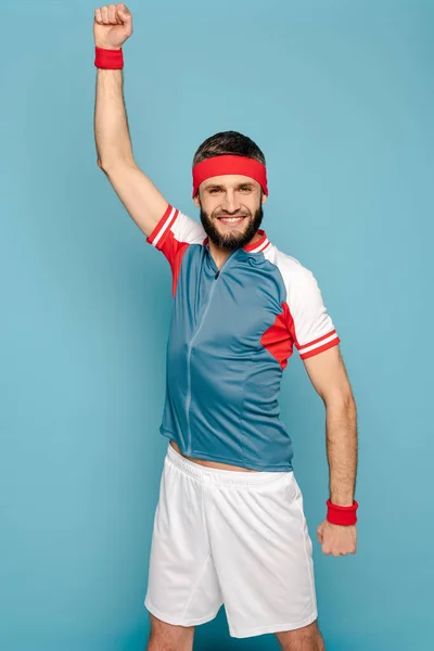 Happy stylish sportsman exercising on blue background — Stock Photo