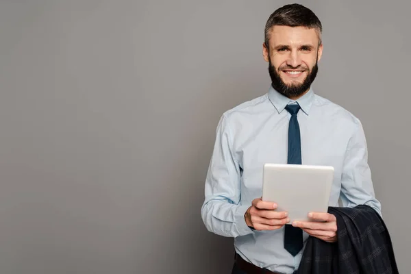 Homme d'affaires barbu beau sourire avec tablette numérique sur fond gris — Photo de stock