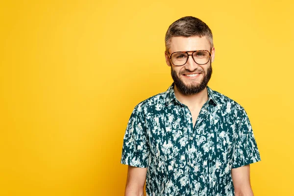 Sorridente ragazzo barbuto in occhiali su giallo — Foto stock