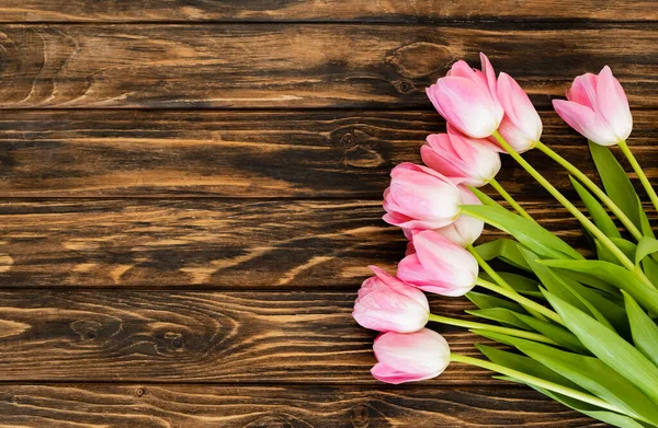 Vue de dessus des tulipes en fleurs sur la surface en bois, concept de fête des mères — Photo de stock