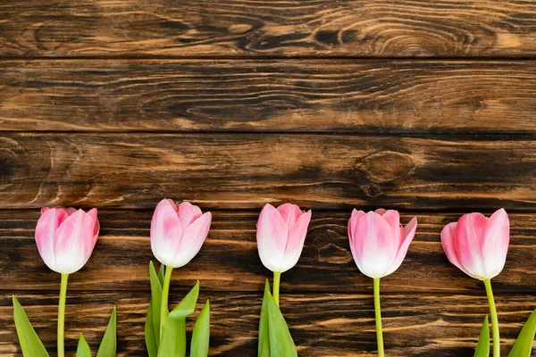 Vista superior de tulipas rosa na superfície de madeira, conceito do dia das mães — Fotografia de Stock