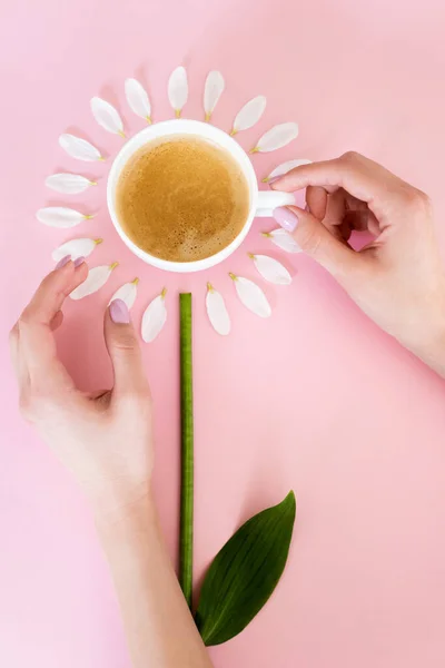 Top view of woman touching cup of coffee near white petals on pink, mothers day concept — Stock Photo