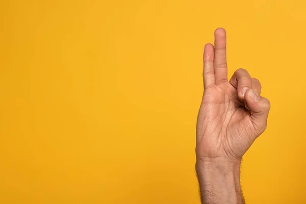 Vista recortada del hombre mostrando una carta del lenguaje de signos cirílico aislado en amarillo - foto de stock