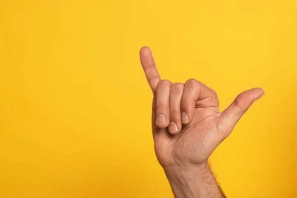 Vista recortada del hombre mostrando la letra cirílica del alfabeto del lenguaje de signos aislado en amarillo - foto de stock