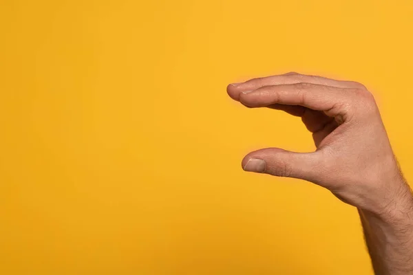 Vista recortada del hombre mostrando una carta del lenguaje de signos cirílico aislado en amarillo - foto de stock