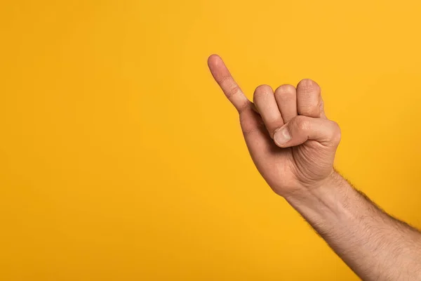 Cropped view of man showing letter in deaf and dumb language isolated on yellow — Stock Photo