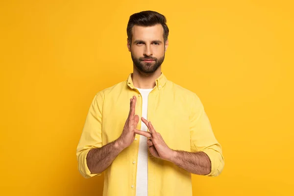 Bearded man showing sign in deaf and dumb language on yellow background — Stockfoto