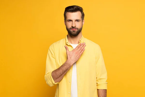 Schöner Mann zeigt Geste aus Gebärdensprache auf gelbem Hintergrund — Stockfoto