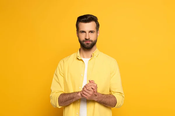 Bonito homem mostrando sinal de casamento em língua surda e muda no fundo amarelo — Fotografia de Stock