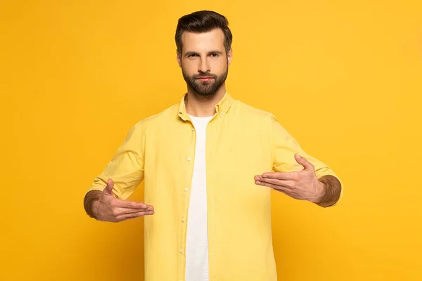 Man looking at camera while using deaf and dumb language on yellow background — Stock Photo