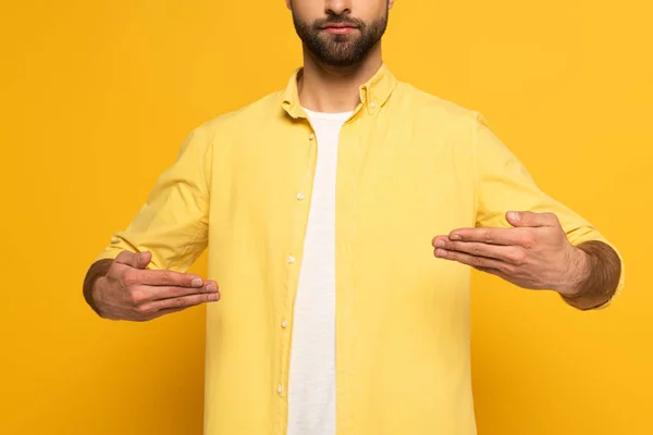 Cropped view of man using deaf and dumb language on yellow background — Stockfoto