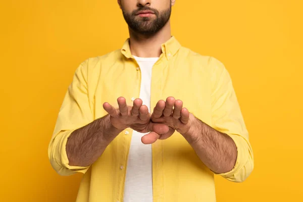 Cropped view of man showing gesture in deaf and dumb language on yellow background — Stock Photo