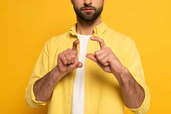 Vista recortada del hombre mostrando signo en lenguaje sordo y mudo sobre fondo amarillo - foto de stock