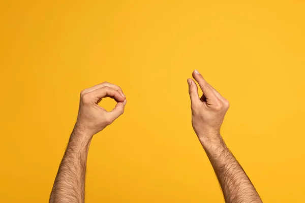 Vista recortada del hombre usando lenguaje de señas aislado en amarillo - foto de stock