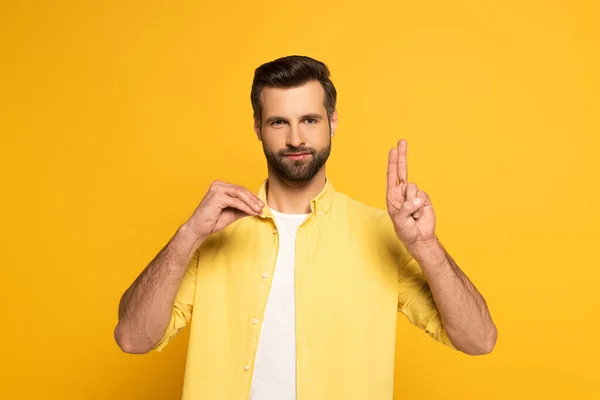 Homem barbudo mostrando letras ao usar linguagem surda e muda no fundo amarelo — Fotografia de Stock