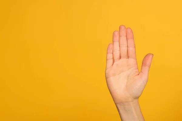 Ausgeschnittene Ansicht der Handfläche der weiblichen Hand isoliert auf gelb — Stockfoto