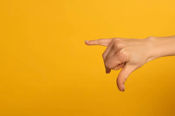 Vista recortada de la mujer usando lenguaje sordo y mudo aislado en amarillo - foto de stock