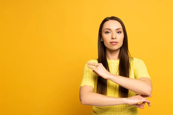 Beautiful woman showing word from deaf and dumb language on yellow background — Stock Photo