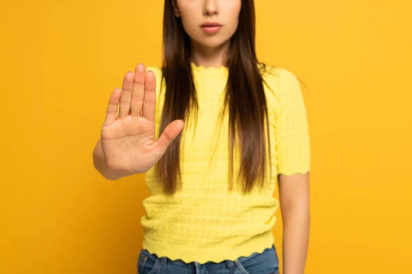 Vista recortada de la mujer que no muestra ningún signo en el fondo amarillo - foto de stock