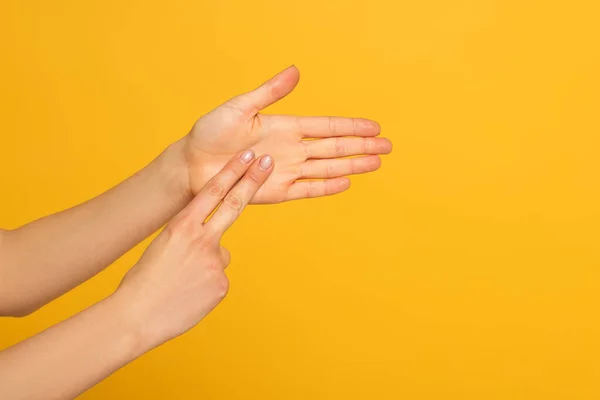 Vista recortada de la mujer usando lenguaje de señas aislado en amarillo - foto de stock