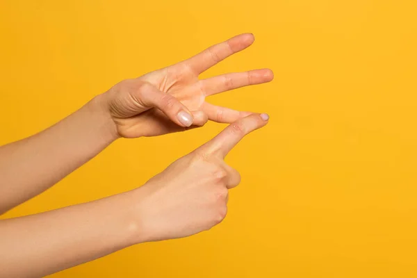 Ausgeschnittene Ansicht einer gestikulierenden Frau, während sie Zeichensprache benutzt, isoliert auf gelb — Stockfoto