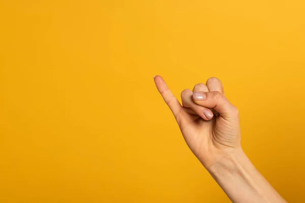 Vista recortada de la mujer que muestra la carta del lenguaje de signos aislado en amarillo - foto de stock