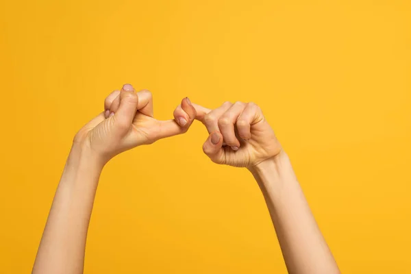 Vista recortada de la mujer que muestra a amigos palabra de lenguaje de señas aislado en amarillo - foto de stock